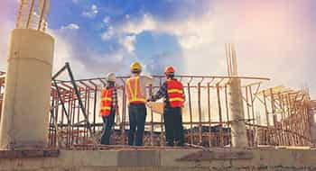 construction workers discussing project plans at a busy worksite